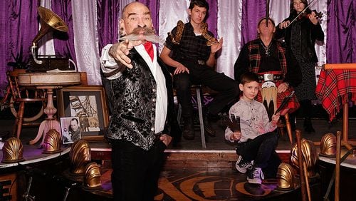 Peter Excho, owner of the Dime Store Museum in Augusta, Ga., believes his museum is the last of its kind in the United States. His shows often include his children: Aden, with snake; Billiey, holding knives; and Theija, on violin. Also pictured family friend Red Stuart, a sword swallower. Credit: Nell Carroll for the AJC