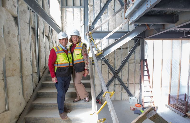 Aurora Theatre's new $31 million theater complex in downtown Lawrenceville is under construction Monday, March 8, 2021.  The theatre's co-founders Anthony Rodriguez, left, Ann-Carol Pence, right, are on the main staircase that runs from the grand theatre lobby to the balcony level.  The project is a partnership with Lawrenceville, and adds two new public performance spaces, creates outdoor green space for the community and provides technical and backstage options significantly increasing the theater's capabilities.  (Jenni Girtman for The Atlanta Journal-Constitution)