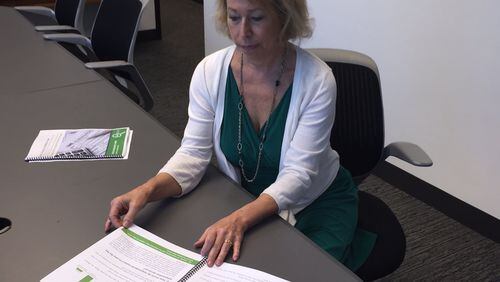 Liz Coyle, executive director of Georgia Watch, looks over the group’s new report on errors and fraud in the tax preparation industry in Georgia.