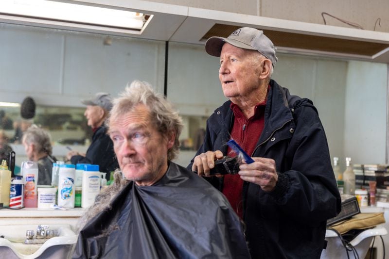 James “Soapy” Herndon cuts the hair of customer Michael Harper in Americus on Saturday, March 4, 2023. Soapy was longtime barber to Jimmy Carter. (Arvin Temkar / arvin.temkar@ajc.com)