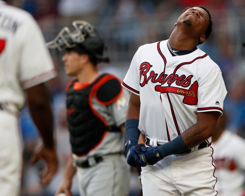 Braves outfielder Ronald Acuna (right) grimaces in pain after being hit by a pitch from Miami Marlins'Jose Urena during the first inning Wednesday , Aug. 15, 2018 in Atlanta. Both dugouts emptied and Urena was ejected. (John Bazemore/AP)