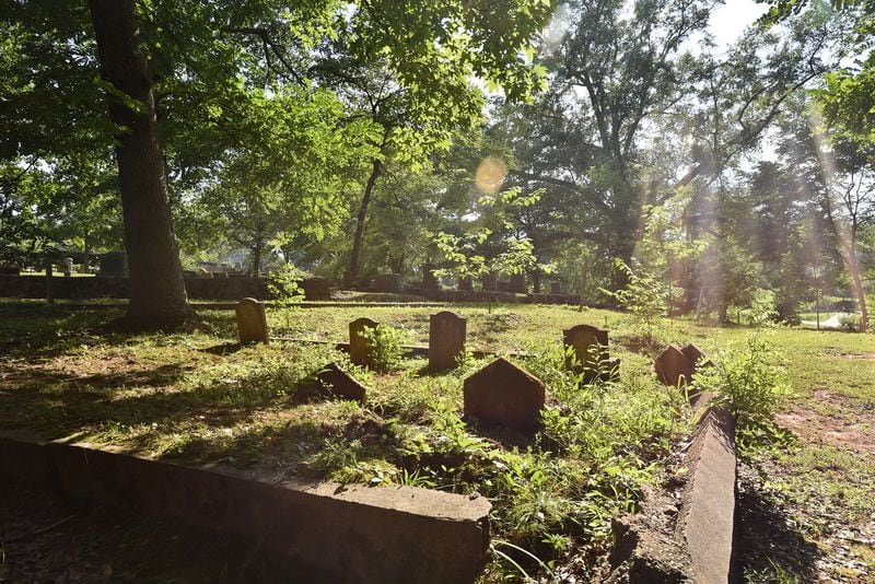 A broken fence and graves covered by overgrown weeds illustrate some of the challenges facing Section 6, the area of the Decatur Cemetery where African Americans were buried during its years of segregation. HYOSUB SHIN / HYOSUB.SHIN@AJC.COM