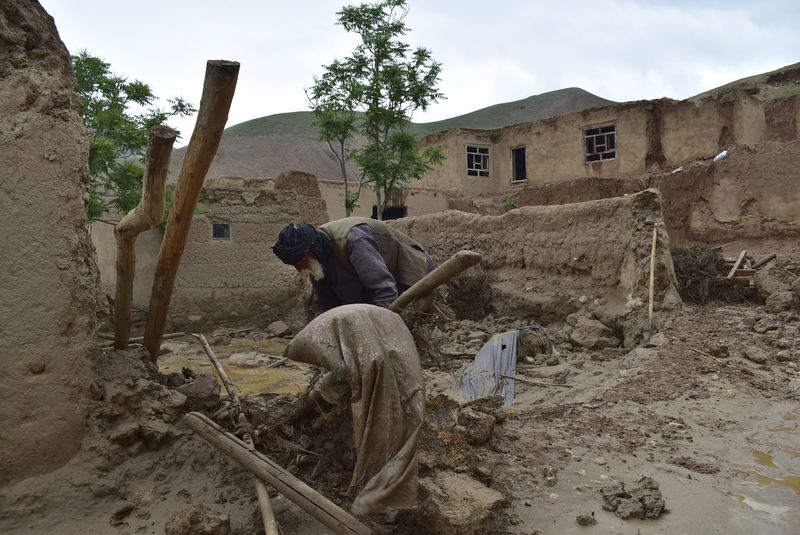 An elderly man collects his belongings from his damaged home after heavy flooding in Baghlan province in northern Afghanistan. Saturday, May 11, 2024. Flash floods from seasonal rains in Baghlan province in northern Afghanistan killed dozens of people on Friday, a Taliban official said. (AP Photo/Mehrab Ibrahimi)