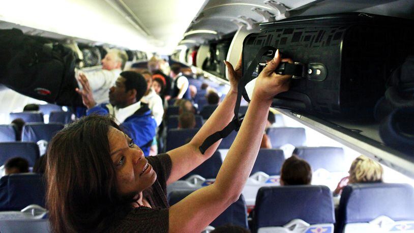 Southwest Airline passenger Robin Bonner, of Solon, Ohio, places her luggage into the overhead compartment on a flight from Midway Airport in Chicago to Cleveland, Ohio, April 2, 2010. (Chris Sweda/Chicago Tribune/TNS)
