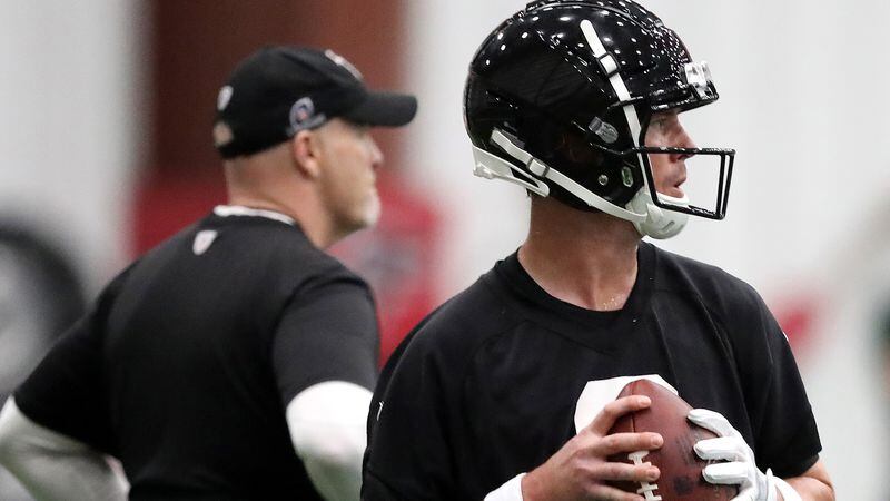Atlanta Falcons quarterback Matt Ryan looks to pass while head coach Dan Quinn watches organized team activities on Tuesday, May 22, 2018, in Flowery Branch.