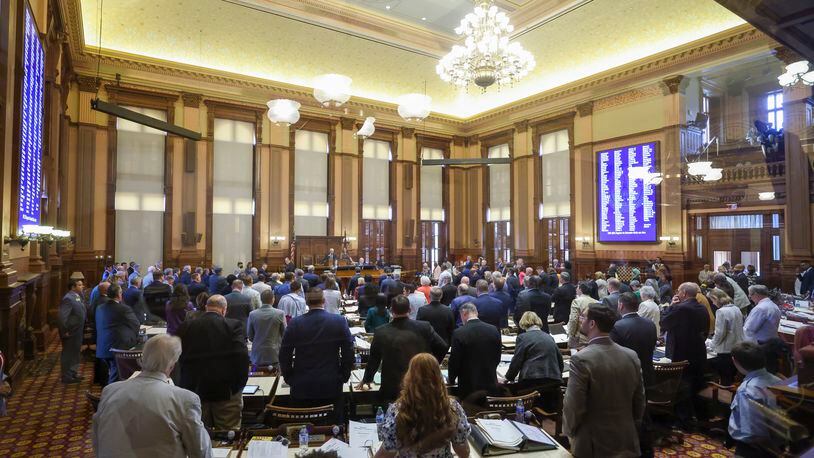 House of Representative members stand at their desks during the announcement of a somber road naming bill, HB 256, in the House Chambers during day 40 of the legislative session at the State Capitol on Wednesday, March 29, 2023. Jason Getz / Jason.Getz@ajc.com)