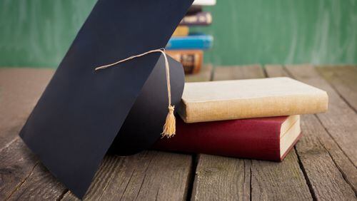 Books and graduation cap on table (stock photo)