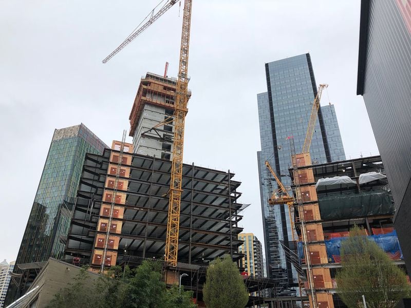 A crane rises over a pair of future office towers at the Seattle headquarters campus of e-commerce giant Amazon in April 2018. (Scott Trubey / Scott.Trubey@ajc.com)