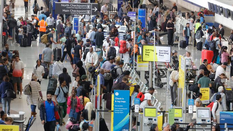 Few face masks were evident as hundreds of travelers walked through the north terminal of Hartsfield-Jackson International Airport in Atlanta on Tuesday, May 9, 2023, two days before the federal government ended the pandemic emergency in the U.S.