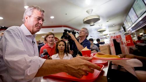 Republican presidential candidate, former Florida Gov. Jeb Bush, left, is handed a hot dog as he visits the Varsity restaurant in downtown Atlanta during a campaign stop on Tuesday. AP/David Goldman