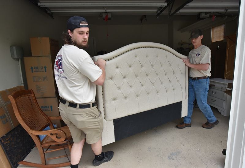 April 15, 2021 Villa Rica - Joe Nowak (left) and Anson Strickland, workers from Barnes Van Lines, move a piece of furniture while moving a family in Villa Rica on Thursday, April 15, 2021. (Hyosub Shin / Hyosub.Shin@ajc.com)