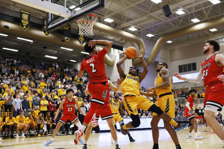 Kennesaw State guard Terrell Burden (1) scrambles to take a shot between Liberty players at Kennesaw State Convention Center on Thursday, Feb 16, 2023.
 Miguel Martinez / miguel.martinezjimenez@ajc.com