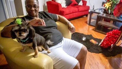 Marcia Body sits in her Jonesboro home with her dog Dora. Body, a cancer survivor, said she had to improvise a face mask when COVID-19 hit the Clayton County Jail. (STEVE SCHAEFER FOR THE ATLANTA JOURNAL-CONSTITUTION)