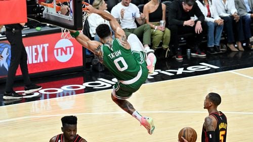 Celtics forward Jayson Tatum hangs on the basket after dunking the ball at the end of the fourth quarter in Game 4 of the first round of the Eastern Conference playoffs at State Farm Arena, Sunday, April 23, 2023, in Atlanta. The Celtics beat the Hawks 129-121. (Hyosub Shin / Hyosub.Shin@ajc.com)