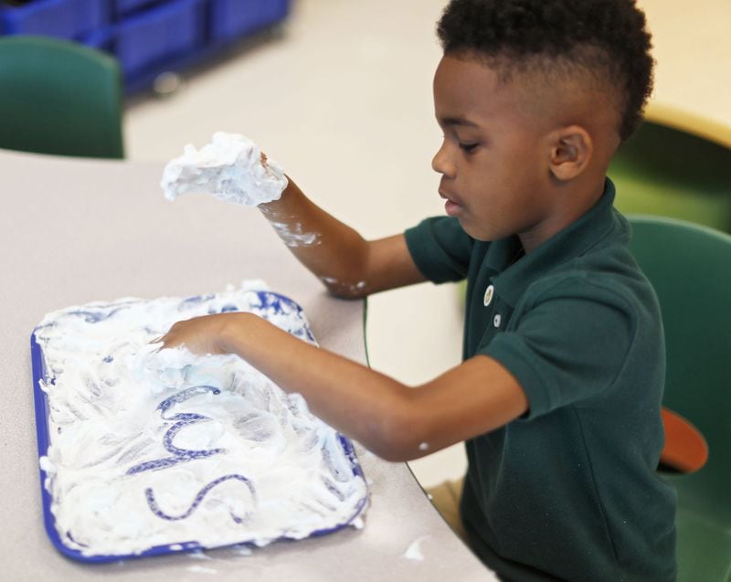Braxton Slaughter, 7, writes in shaving cream in the literary center at Charles R. Drew Charter School on April 18, 2019. Nonsense “words” ensure students can apply phonics rules. Students at Drew who struggle with reading get the kind of “multisensory” interventions envisioned by Senate Bill 48. In addition to mandatory statewide screening for dyslexia in kindergarten, which Drew already does, the bill mandates teacher training that may look like what’s already happening at the Atlanta school. 
