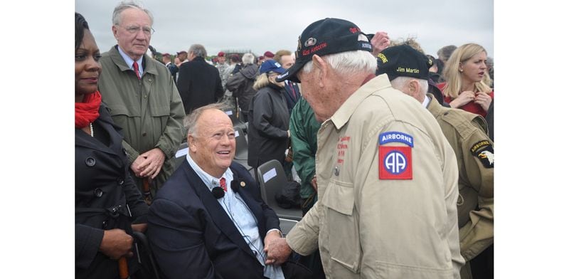 Former U.S. Senator Max Cleland, D-Ga., now secretary of the American Battle Monuments Commission, meets with D-Day veterans following a ceremony at Pointe-du-Hoc in Normandy, France, on June 5, 2014.