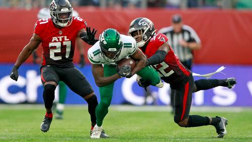 New York Jets wide receiver Denzel Mims (11) is tackled by Falcons safety Richie Grant (27) and safety Jaylinn Hawkins (32) during the second half Sunday, Oct. 10, 2021, at the Tottenham Hotspur stadium in London. (Ian Walton/AP)