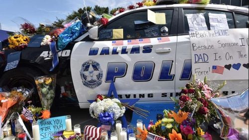 A police car is decorated as a public memorial in front of Dallas police headquarters Saturday morning. HYOSUB SHIN / HSHIN@AJC.COM