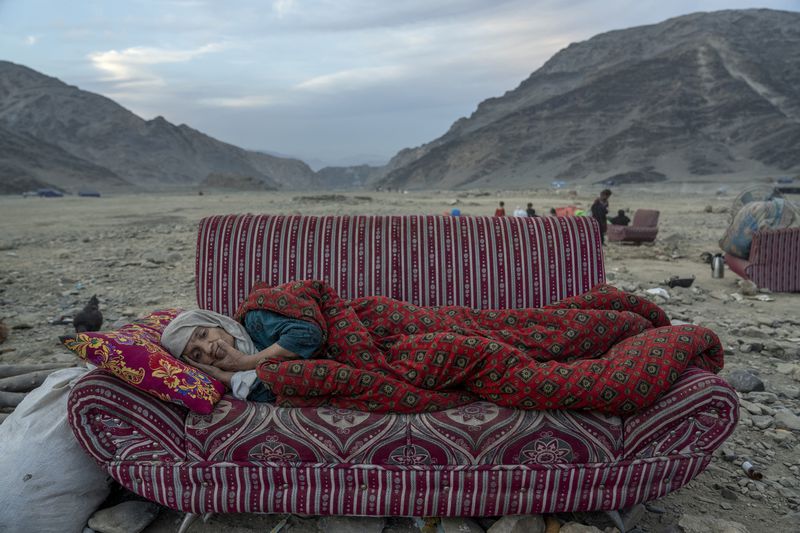 This image provided by World Press Photo is part of a series titled Afghanistan on the Edge by Ebrahim Noroozi, Associated Press, which won the World Press Photo Asia Series category and showsAn Afghan refugee rests in the desert next to a camp near the Torkham Pakistan-Afghanistan border, in Torkham, Afghanistan, Friday, Nov. 17, 2023. A huge number of Afghans refugees entered the Torkham border to return home hours before the expiration of a Pakistani government deadline for those who are in the country illegally to leave or face deportation. (AP Photo/Ebrahim Noroozi)