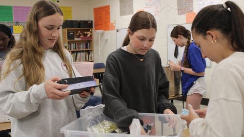 Dickerson Middle School students Marlow Cornell, Ali Diaz and Isabella Janeira are members of the Pay It Forward club. Here, they pack bags of toiletries for families staying in Ronald McDonald Houses in Atlanta.