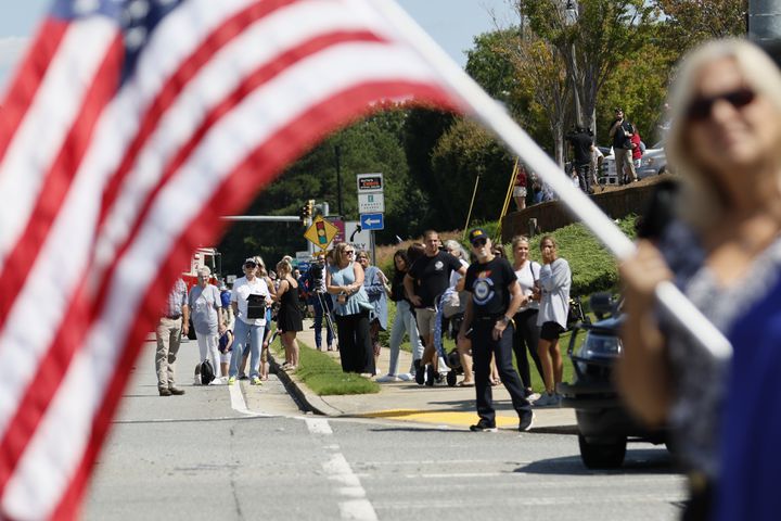 People stand by Chastain Rd to pay respect to fallen Deputy Jonathan Koleski during the procession on Wednesday, September 14, 2022. Miguel Martinez / miguel.martinezjimenez@ajc.com