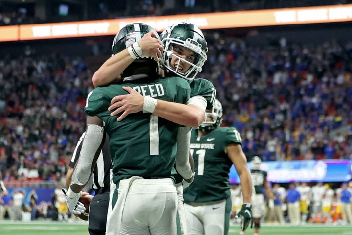 Michigan State Spartans wide receiver Jayden Reed (1) celebrates his go-ahead touchdown with quarterback Payton Thorne, facing, in the fourth quarter against the Pittsburgh Panthers in the Chick-fil-A Peach Bowl at Mercedes-Benz Stadium in Atlanta, Thursday, December 30, 2021. JASON GETZ FOR THE ATLANTA JOURNAL-CONSTITUTION