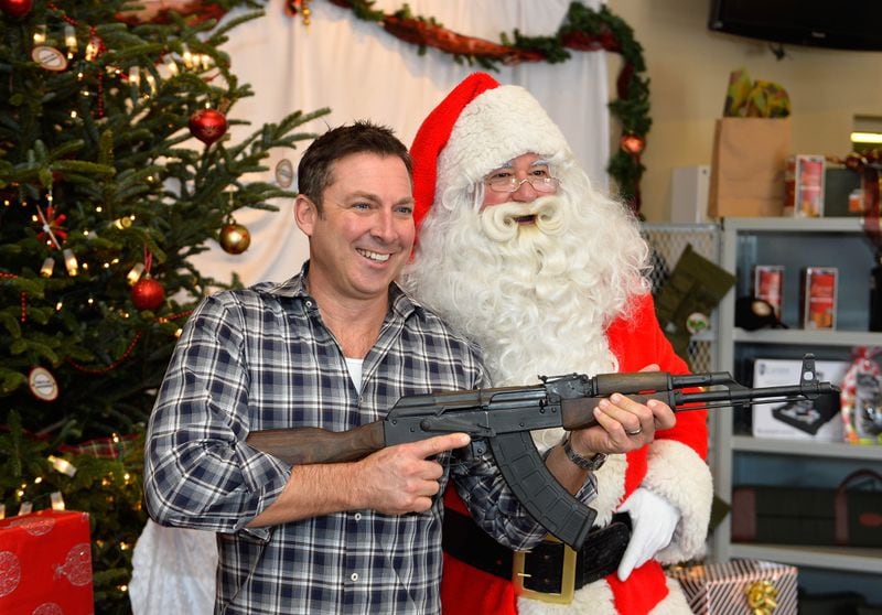 Firearms supporter Jim Thomas, left, poses for photos with Santa Claus David Doerrier at the Sandy Springs Gun Club and Range for an opportunity to express their holiday spirit and passion for firearms on Saturday, Dec. 13, 2014, in Sandy Springs, Ga. David Tulis/AJC Special