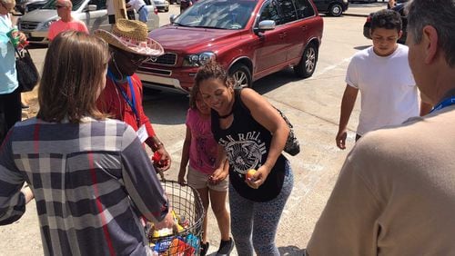 Luis Perez, in the white shirt, and his mother take snacks and drinks given out by a Macon church at a Bibb County rest stop Friday, Sept. 8, 2017. Perez, 15, said 10 of his family members drove in two cars from Homestead, Florida, to escape Hurricane Irma.