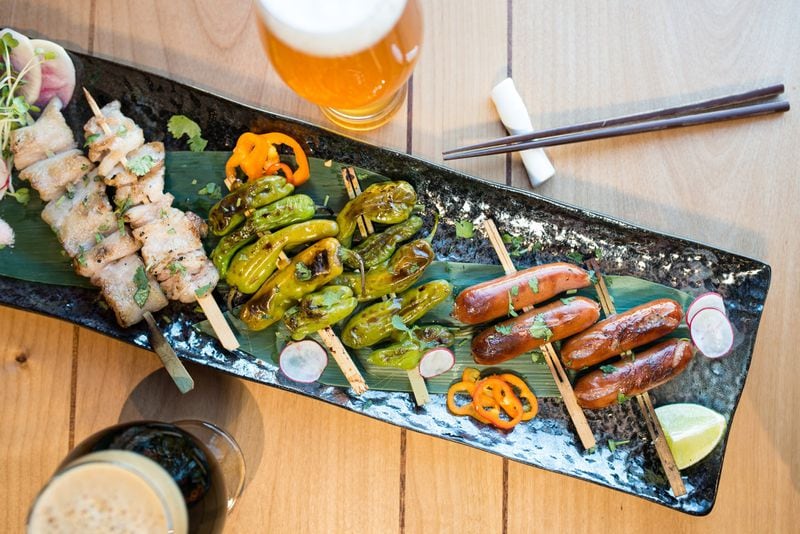  Hopstix Robatayaki plate with Silky Pork Belly, Shishito Peppers, and Kurobuta Sausage. Pictured with Wrecking Bar Jemmy Stout and Max Lager's Hopslosion. Photo credit- Mia Yakel.