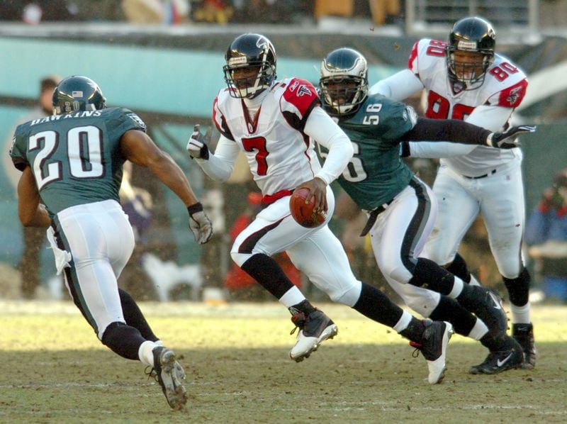   Falcons quarterback Mike Vick scrambles upfield for a long run under pursuit by Eagles Brian Dawkins (20) and Derrick Burgess (56) while Falcons' end Eric Beverly (80) makes the block in the backfield in the first quarter of the NFC Championship game at Lincoln Financial Field on Sunday, January 23, 2005. (CURTIS COMPTON/AJC staff)