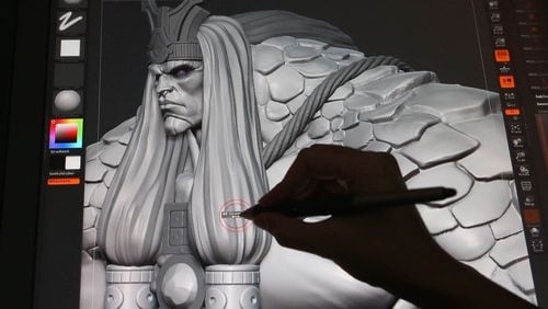 Brian Wells, a concept artist, works on Cabrakan, Destroyer of Mountains, a character in "SMITE," created by Alpharetta-based Hi-Rez Studios, on Nov. 3, 2014.