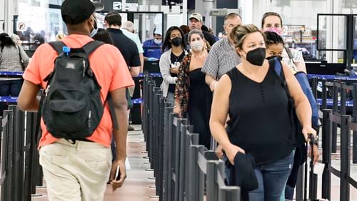 Masked and unmasked passengers walk through security checkpoint at Hartsfield-Jackson International Airport on Tuesday, July 19, 2022.  (Natrice Miller/natrice.miller@ajc.com)