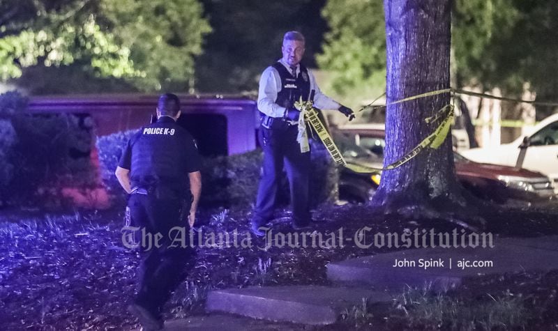 Alpharetta police officers remove crime scene tape at a complex off Mansell and Old Roswell roads, where a man was fatally shot. 