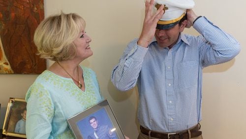 Heidi Hetzler watches as Greg Ambrosia tries on his hat when they met for the first time after she returned the hat he wore for graduation from West Point in 2005. He threw his hat at the graduation ceremony never expecting to see it back. But recently Heidi found it cleaning her son's room. PHIL SKINNER FOR THE ATLANTA JOURNAL-CONSTITUTION