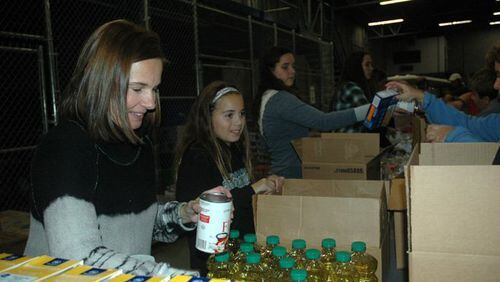 Volunteers pack food boxes to be donated to needy families through CAC.
