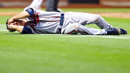 Atlanta Braves starting pitcher Max Fried lies on the ground during the third inning. Fried slammed the ground while chasing an errant throw but stayed in the game. (AP Photo/Jessie Alcheh)