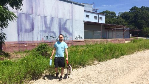 Avi Gelfond and his dog, Frankie, on a walk on the Beltline next to property that is getting a tax break for new apartments. “Why are they giving tax breaks for this property when our taxes are going up? It seems absurd,” Gelfond said. (Photo by Bill Torpy)