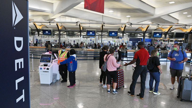 Delta Air Lines employees assist customers in the Domestic Terminal at Hartsfield-Jackson Atlanta International Airport in Atlanta on Tuesday, October 5, 2021. (Hyosub Shin / Hyosub.Shin@ajc.com)
