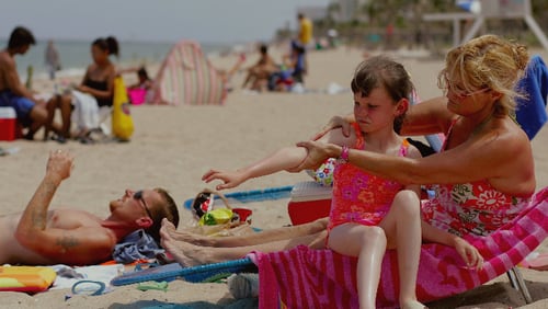 Sharon Doyle puts sunscreen on the arm of 9-year-old Savannah Stidham as they visit the beach June 20, 2006 in Fort Lauderdale, Florida.