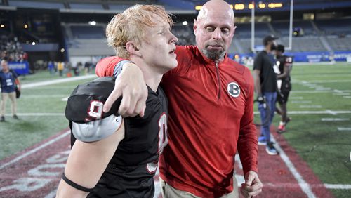 State champs: Bowdon head coach Rich Fendley celebrates with Asher Christopher (9) after beating Schley County 39-31 Thursday in the Class A Division 2 state championship game at Georgia State's Center Parc Stadium. (Daniel Varnado/For the AJC)