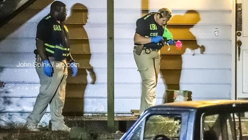 GBI agents collect evidence at the scene of an officer-involved shooting on Ellison Court in south Cobb County early Thursday morning. A Cobb County police officer and a suspect were both wounded in the shooting, according to police.