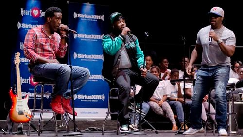 Shawn Stockman, from left, Wanya Morris, and Nathan Morris of the musical group Boyz II Men, perform at their alma mater, Creative and Performing Arts High School, Tuesday, Oct. 14, 2014, in Philadelphia. (AP Photo/Matt Rourke)