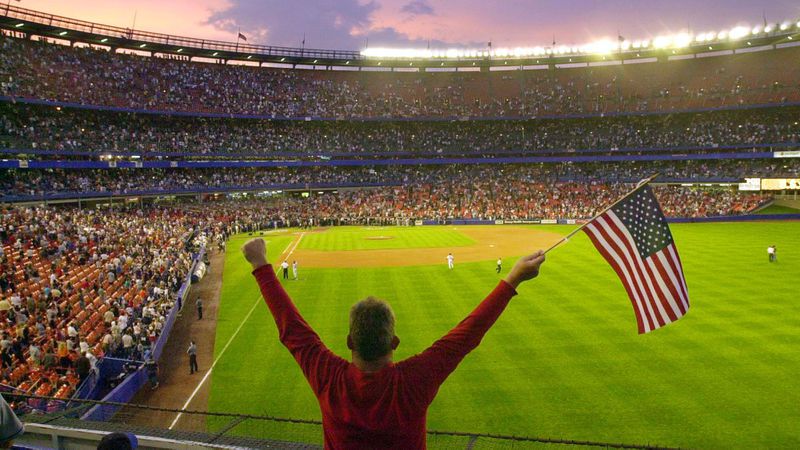 Bobby Amos stand with his arms in the air holding a flag before the start of a game between the New York Mets and the Atlanta Braves at Shea Stadium in New York Friday, Sept. 21, 2001.