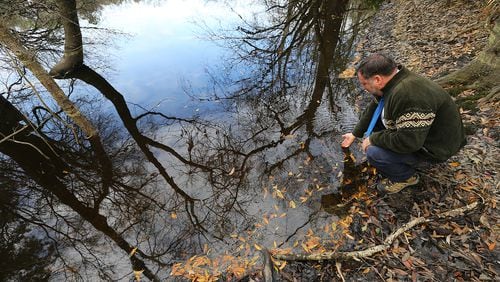 Valdosta State University Professor Don Thieme checks the water color and clarity in a sinkhole near the site of a proposed Sabal Trail pipeline. Curtis Compton / ccompton@ajc.com