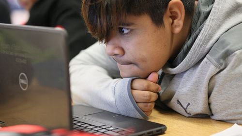 Seventh grader Melvin Evaristo, 12, uses a school laptop during a reading class at Crabapple Middle School on Friday, Feb. 21, 2020, in Roswell. At Crabapple Middle School, the adults are specific about their tech use. When it’s for an assignment, the devices come out. MIGUEL MARTINEZ FOR THE ATLANTA JOURNAL-CONSTITUTION