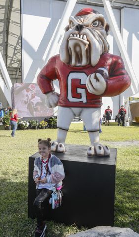 10/30/21 - Jacksonville - Taylor Grace Dibble,  8, stands with the UGA mascot for a photo taken by her mother at the fan experience outside the stadium at the annual NCCA  Georgia vs Florida game at TIAA Bank Field in Jacksonville.   Bob Andres / bandres@ajc.com