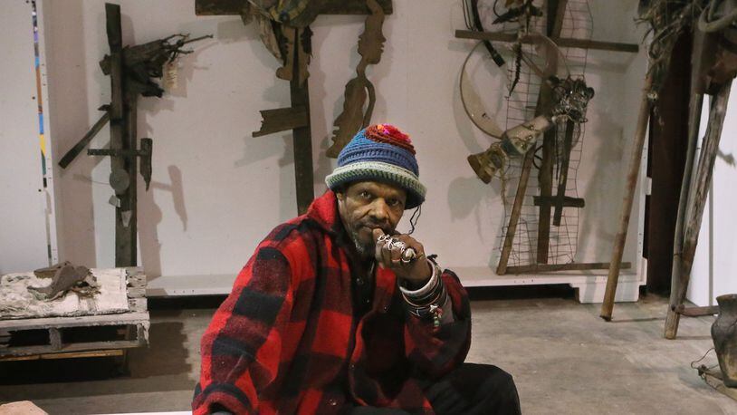 Artist Lonnie Holley, who recently moved to Atlanta, in collector William Arnett’s warehouse, which contains some of Holley’s artworks including this granite construction called “Mith.” BOB ANDRES / BANDRES@AJC.COM
