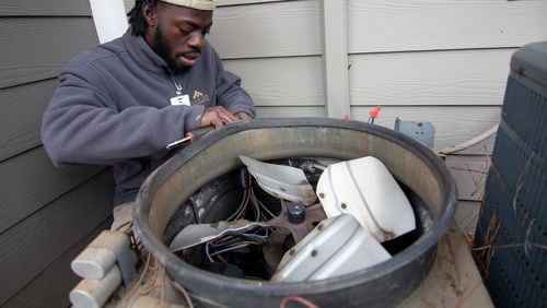 Moma Sayplay works on repairing a heat pump at the Gables Mills Apartments Monday, February 10, 2020. STEVE SCHAEFER / SPECIAL TO THE AJC