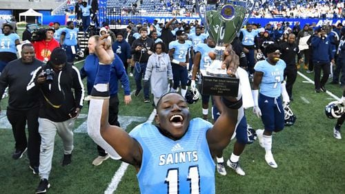 Cedar Grove's Isaiah Ratcliff celebrates with the trophy after the AAA state title football game win over Crisp County on Saturday Dec.14, 2019. John Amis / Special