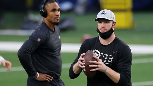 Eagles quarterbacks Jalen Hurts (left) and Carson Wentz warm up before a game against the Dallas Cowboys in December.